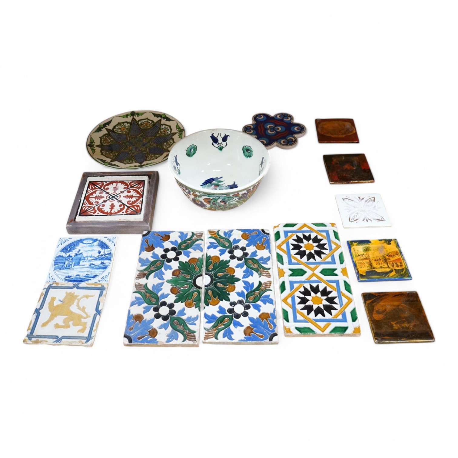 A collection of European tiles, to include a German rampant lion example, dishes and a Belgian bowl, largest 27cm in diameter. Condition - varies